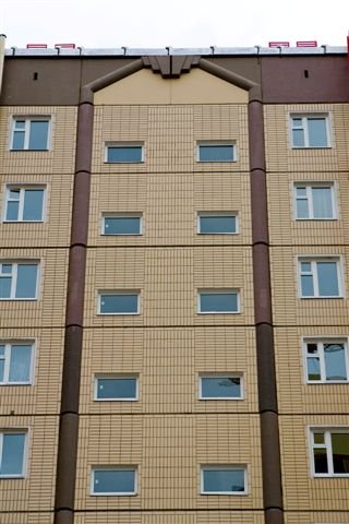 Довършване на фасадата на многоетажна сграда с глигани плочки Довършване на фасадата на многоетажна сграда с глигани плочки