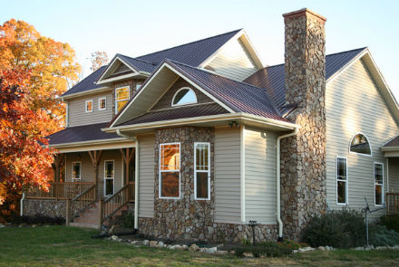 Finition extérieure d'une maison privée. Un exemple de revêtement de façade combiné avec parement et pierre naturelle Finition extérieure d'une maison privée. Un exemple de revêtement de façade combiné avec parement et pierre naturelle