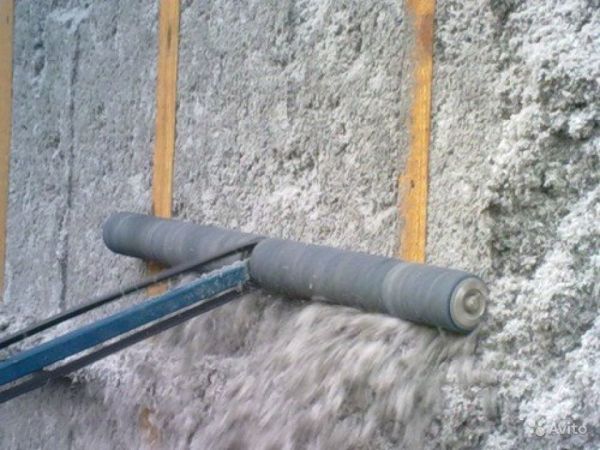 Après avoir appliqué du PPU sur les murs, son excès est éliminé avec un outil spécial Après avoir appliqué du PPU sur les murs, son excès est éliminé avec un outil spécial