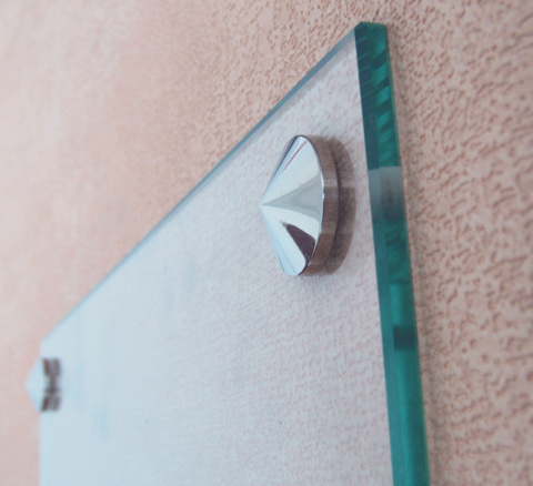 Vemos como o espelho fica nas cavilhas na parede.