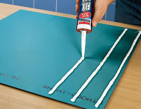 Vemos o processo de aplicação de cola no espelho.