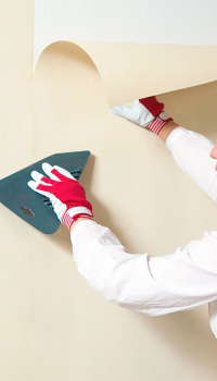 With a rubber spatula, the strip is leveled and the excess glue is squeezed out from under the canvas.