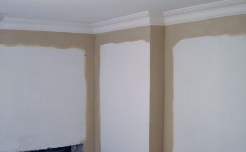 Ecken und Nebenräume eines Deckensockels werden mit einem Pinsel bemalt