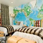 Κουτιά παιχνιδιών με τη μορφή κιβωτίων πεζοπορίας και χάρτη στον τοίχο σας προσκαλούν σε ένα φανταστικό ταξίδι